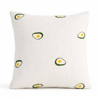 White pillow with avocado pattern on a white background