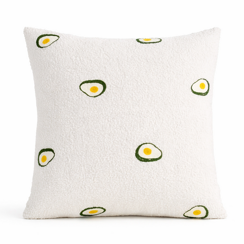 White pillow with avocado pattern on a white background