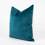 Teal velvet pillow on a white background
