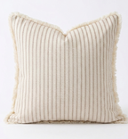 A square throw pillow with vertical beige stripes on a cream background and fringed edges, photographed against a plain white background. Great for Beach style decor. Pillow cover has a zipper so cover can be removed and washed. Insert sold separately. 