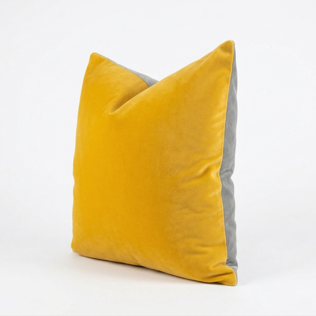 Yellow velvet pillow with gray back on a white background