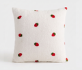 A square white sherpa throw pillow with a pattern of embroidered red strawberries, shown against a plain white background. Pillow cover has a zipper and can be removed and is washable. Insert sold separately. 