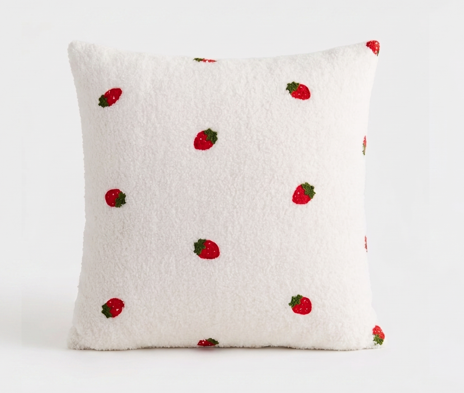 A square white sherpa throw pillow with a pattern of embroidered red strawberries, shown against a plain white background. Pillow cover has a zipper and can be removed and is washable. Insert sold separately. 