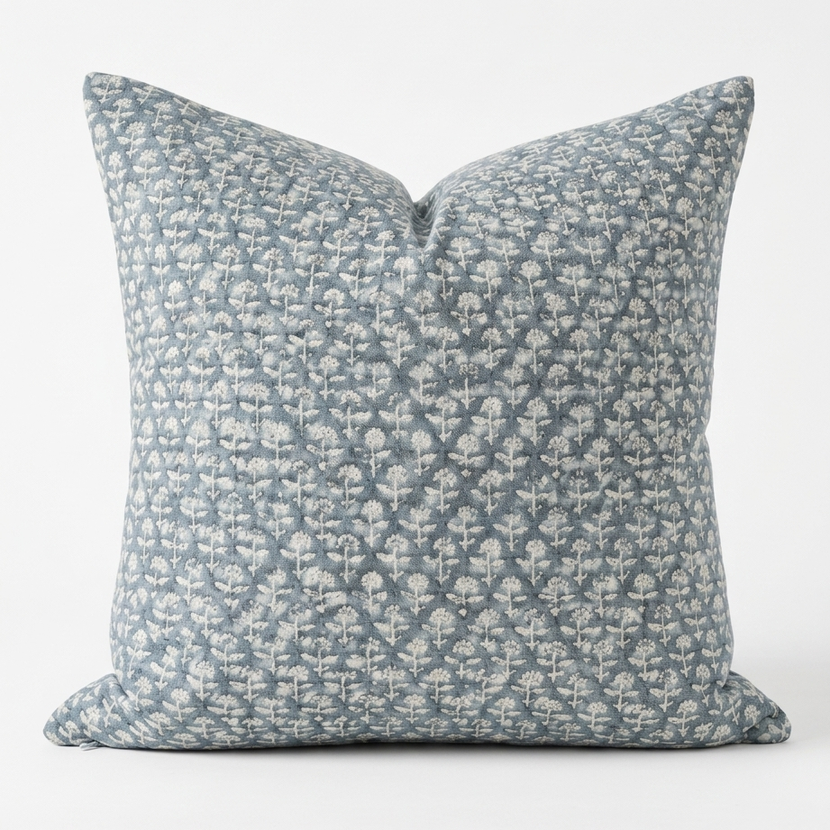 Decorative throw pillow with a blue and white pattern on a white background