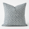 Decorative throw pillow with a blue and white pattern on a white background