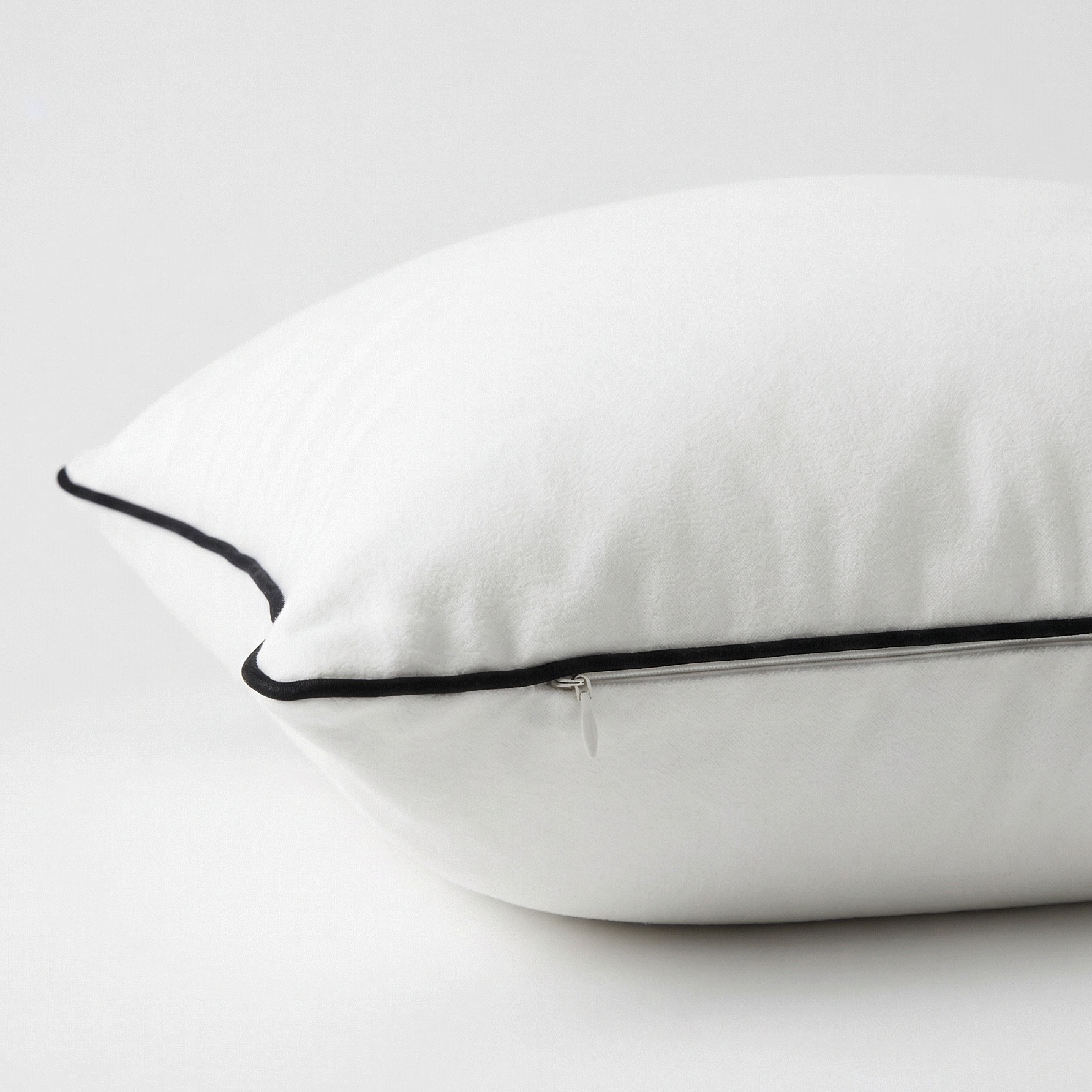 White velvet pillow with black trim. Pillow cover is removable with featured side zipper.