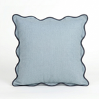 Blue pillow with scalloped edge on a white background