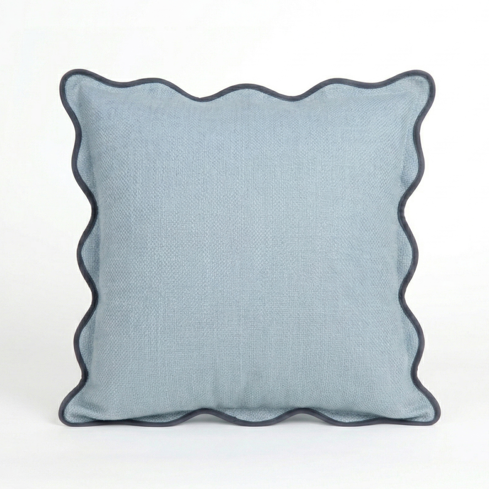 Blue pillow with scalloped edge on a white background