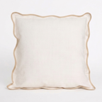 White pillow with beige, scalloped trim on a white background