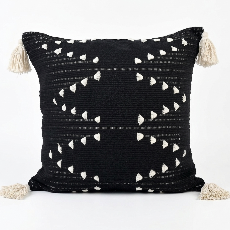 Black pillow with white pattern and tassels on a white background. Pillow cover is removable for easy cleaning.