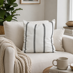 White pillow with black stripes on a beige sofa in a cozy living room.